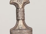 an old silver bell is sitting on top of a wooden table
