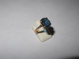 an image of a ring with a blue stone on it