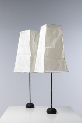 une paire de lampes blanches avec des pieds noirs posées sur une table blanche