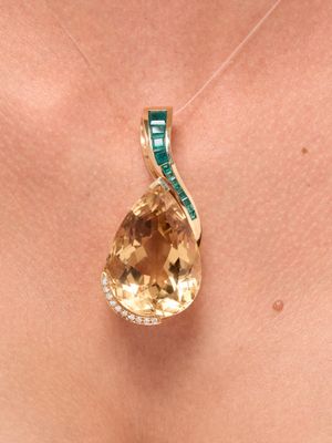 an image of a close up of a woman ' s neck with a necklace with a yellow topazne