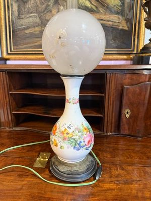 une lampe posée sur une table devant un tableau