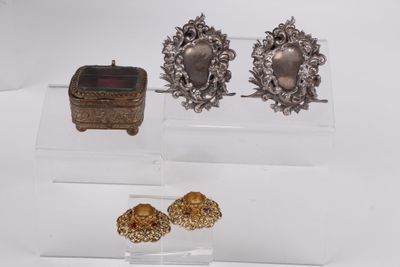 deux paires de boucles d'oreilles en argent et un écrin posés sur une surface blanche