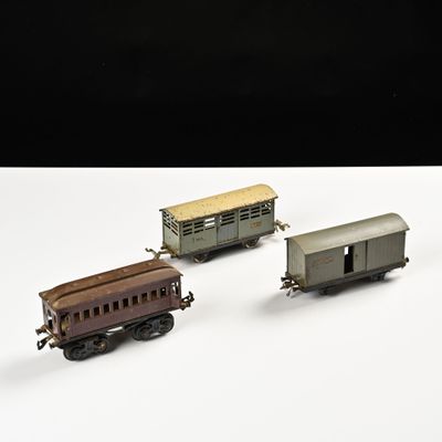 trois petits trains assis l'un à côté de l'autre sur une surface blanche