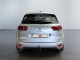 the rear end of a silver citrole parked in a white room