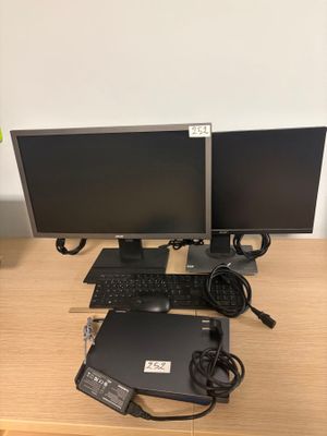 two computer monitors and a keyboard on the desk