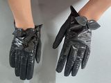 pair of black leather gloves on a woman ' s legs