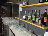 bottles and glasses are lined up on a counter in a bar
