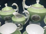 a lot of tea cups and saucers sitting on a table