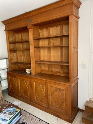 a large wooden bookcase in the corner of a living room