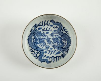 une assiette bleue et blanche ornée d'un motif représentant un dragon