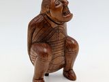a close up of a wooden figurine of a monkey on a white background