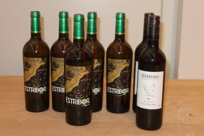 six bouteilles de vin sont alignées sur une table en bois