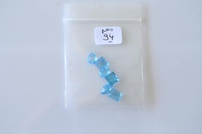 un petit sachet de perles en plastique bleues posé sur une table blanche