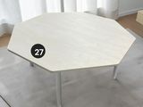 une table blanche sur laquelle est inscrit un numéro, dans une pièce