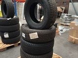 tires stacked on pallets in a warehouse with boxes and pallets in the background