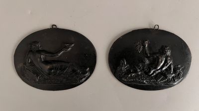deux médaillons noirs représentant un homme et une femme dans un champ