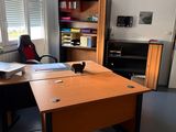 a desk with a chair and a book shelf in the corner