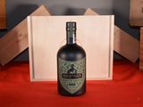 a bottle of liquor sitting on a table next to wooden crates