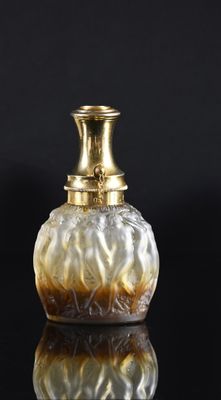 an image of a glass vase with a gold top on a black surface