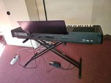 a keyboard and a laptop on a stand in a room
