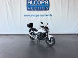 une moto blanche garée devant un mur blanc