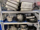 de nombreuses casseroles et poêles sur les étagères de la cuisine