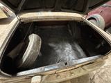 an open trunk of a car with a tire inside of it