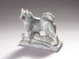 statue représentant un chien debout sur un rocher, posée sur un fond blanc