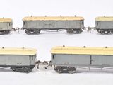 quatre wagons gris et jaunes posés sur une surface blanche