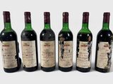 six bouteilles de vin sont alignées dans une rangée