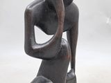 an image of a sculpture of a woman sitting on a rock