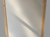 a close up of a mirror with a wooden frame on a wall