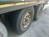 a green truck with a flat tire parked on the side of the road