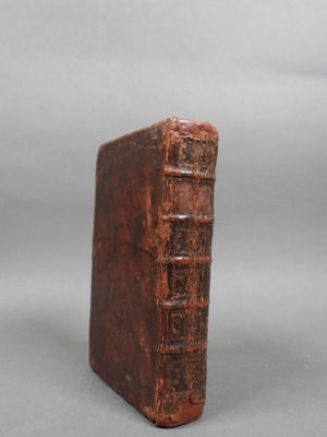 an old book sitting on top of a table next to a gray background