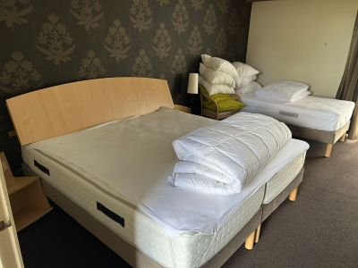 deux lits dans la chambre, recouverts de draps blancs