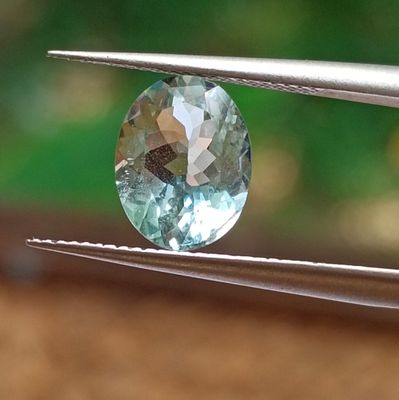 a close up view of a blue diamond being held by a pair of pliers
