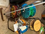 many different types of hoses and reels hanging on the wall