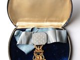 une petite boîte contenant une médaille et un ruban