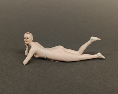 a figurine of a woman laying on the ground