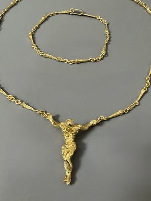 Gros plan sur un collier en or orné d'une croix