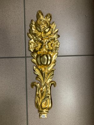 a gold wall mounted clock on the wall of a bathroom