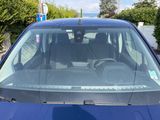 a bird sitting on the windshield of a blue car