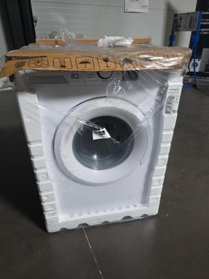 une machine à laver blanche posée au milieu d'une pièce