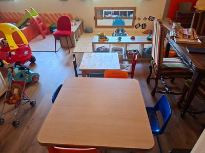 une pièce avec une table, des chaises et des jouets