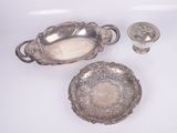 three pieces of silverware are sitting on a white surface