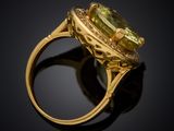 a close up of a gold ring with a green stone in it