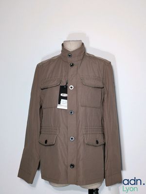 La veste est marron et porte une étiquette.