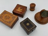 four small wooden boxes and a candle holder on a white surface
