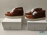 deux paires de chaussures marron sont posées sur des cartons