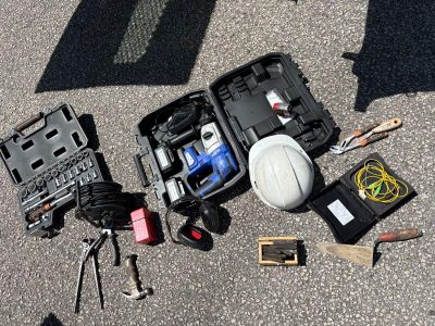 un casque de chantier, des outils et d'autres objets disposés par terre